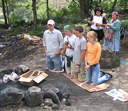 Students nealing in front of ceremonial objects during a Mayan ceremony.