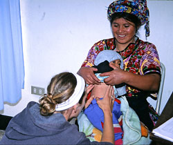 Student examining a baby.