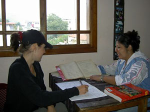 A student and teacher studying at a desk.